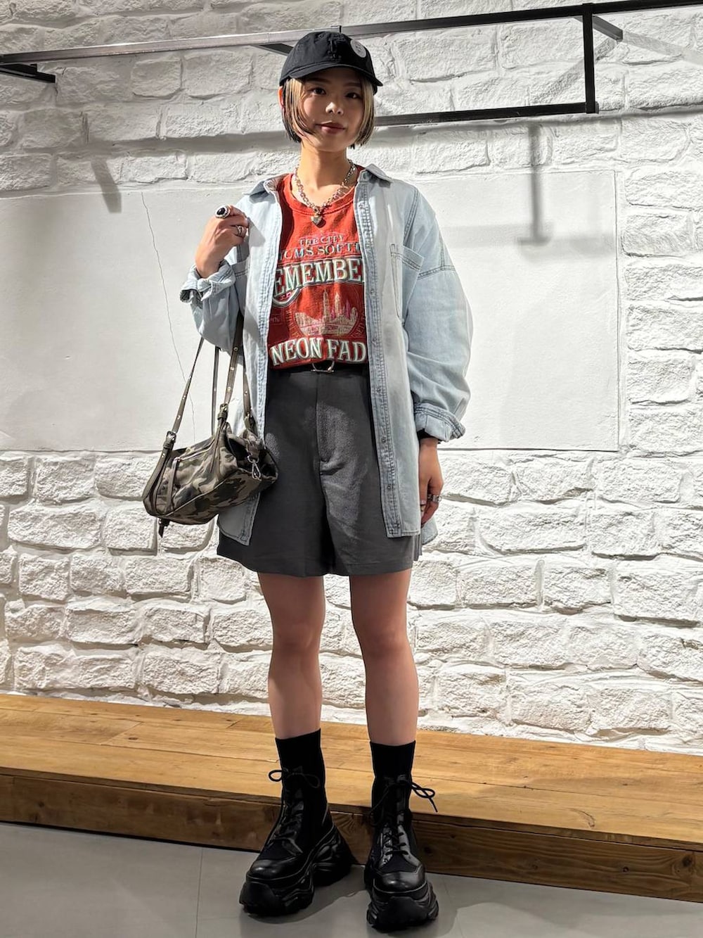 ブラック系のブーツ、ブルー系のシャツ/ブラウス、レッド系のTシャツ/カットソーを着用したレディースの春コーディネートの2枚目の写真