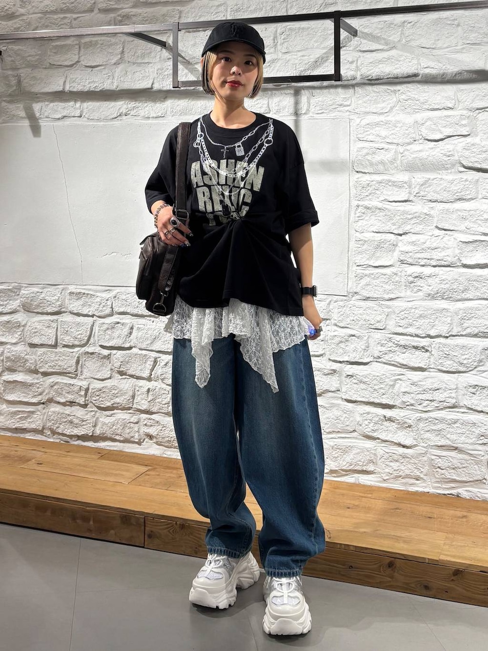 ブラック系のTシャツ/カットソー、ホワイト系のスニーカー、ブラウン系のショルダーバッグを着用したレディースの夏コーディネートの2枚目の写真