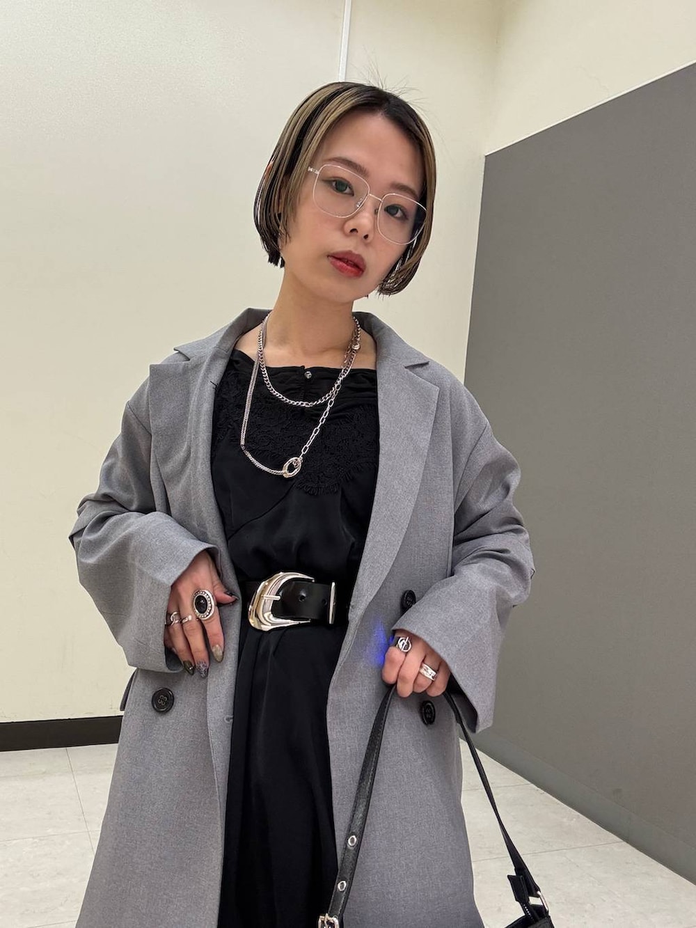 ブラック系のスニーカー、ブラック系のチュニック、ブラック系のハンドバッグを着用したレディースの春コーディネートの10枚目の写真