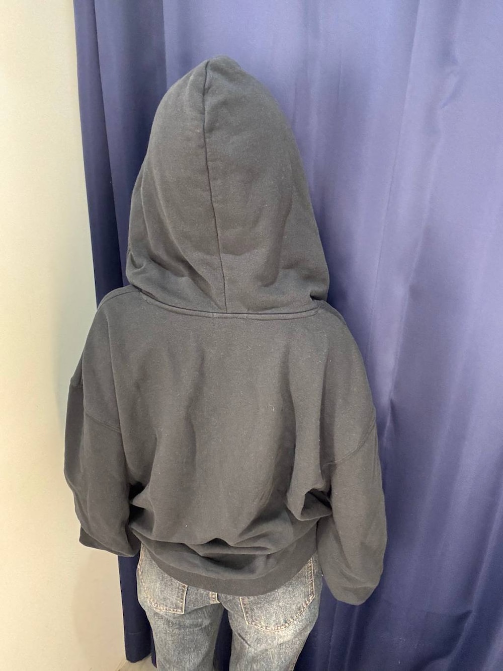 ブラック系のパーカー、ブルー系のデニムパンツを着用したレディースの秋コーディネートの3枚目の写真