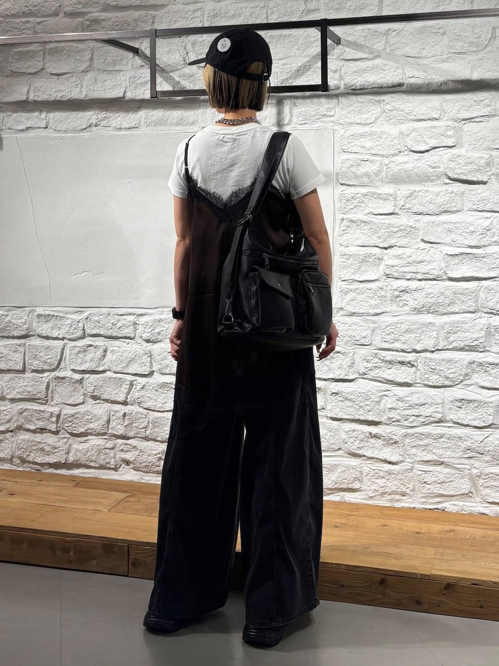ブラック系のデニムパンツ、ブラウン系のチュニック、ホワイト系のTシャツ/カットソーを着用したレディースの夏コーディネートの6枚目の写真