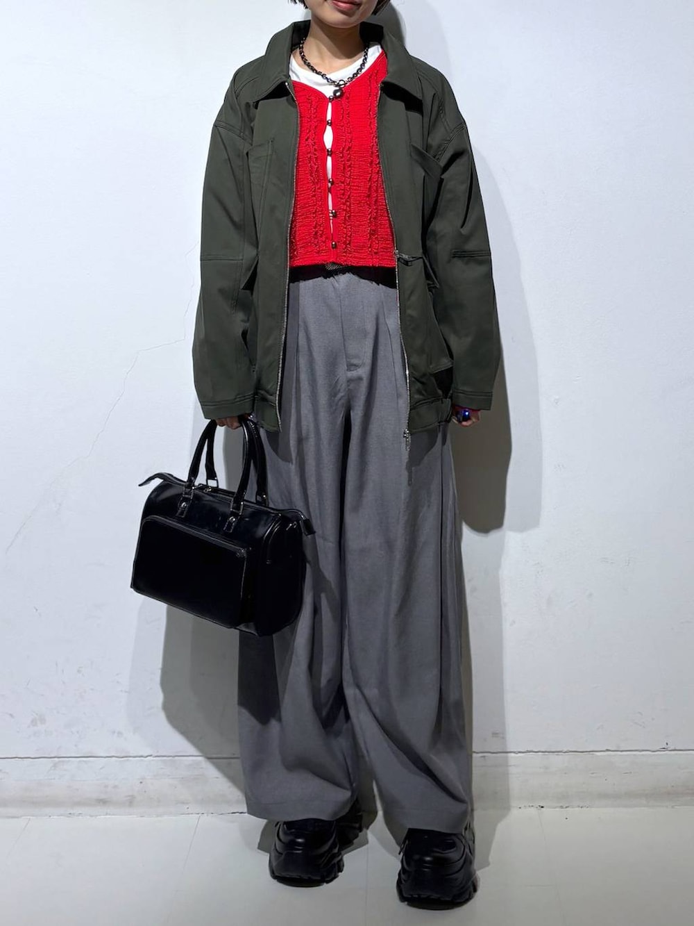 ホワイト系のスニーカー、ブラック系のショルダーバッグ、ホワイト系のTシャツ/カットソーを着用したレディースの春コーディネートの2枚目の写真