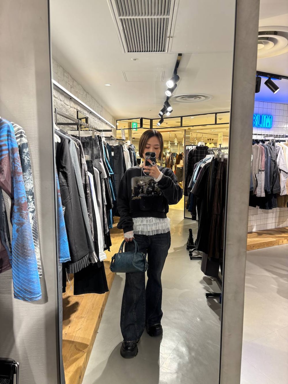 ホワイト系のTシャツ/カットソー、ブラック系のスニーカー、ブルー系のデニムパンツを着用したレディースの秋コーディネートの4枚目の写真
