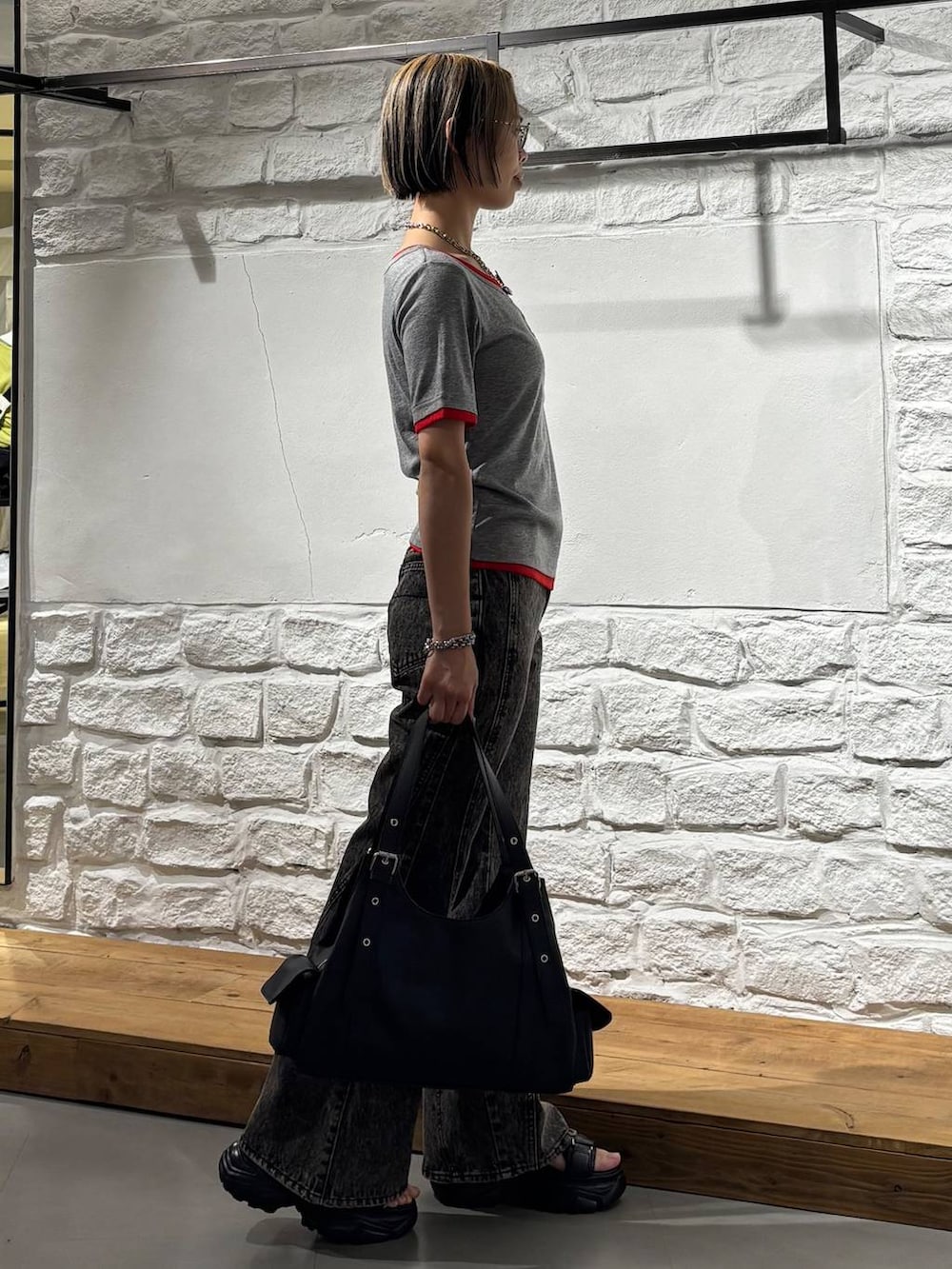 ブラック系のデニムパンツ、ブラック系のサンダル、ブラック系のハンドバッグを着用したレディースの春コーディネートの4枚目の写真