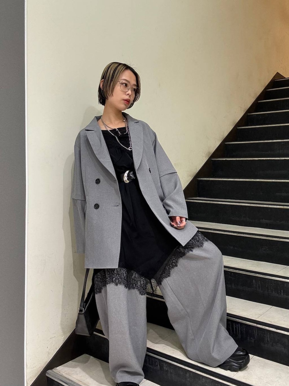 ブラック系のスニーカー、ブラック系のチュニック、ブラック系のハンドバッグを着用したレディースの春コーディネートの4枚目の写真