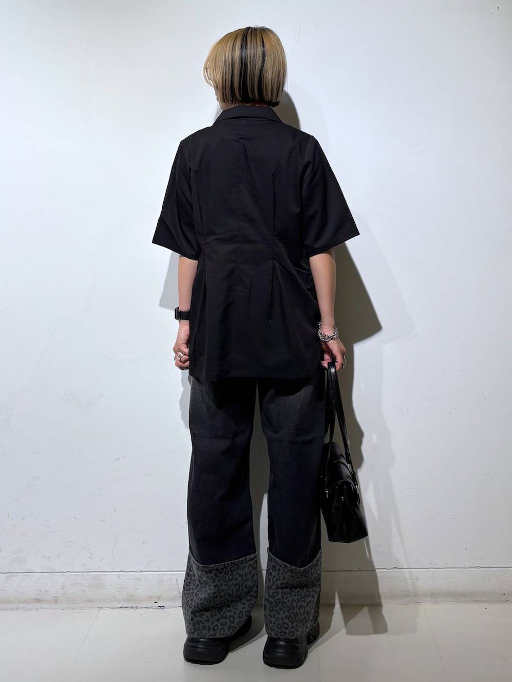 ホワイト系のTシャツ/カットソー、ブラック系のスニーカー、ブラック系のデニムパンツを着用したレディースの夏コーディネートの5枚目の写真