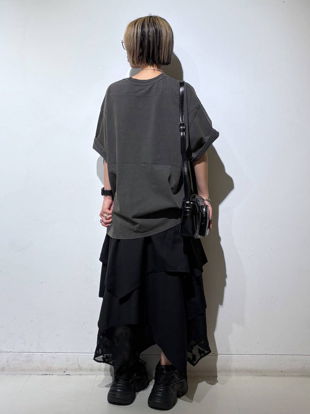 ブラック系のスニーカー、ブラック系のショルダーバッグ、グレー系のTシャツ/カットソーを着用したレディースの夏コーディネートの5枚目の写真