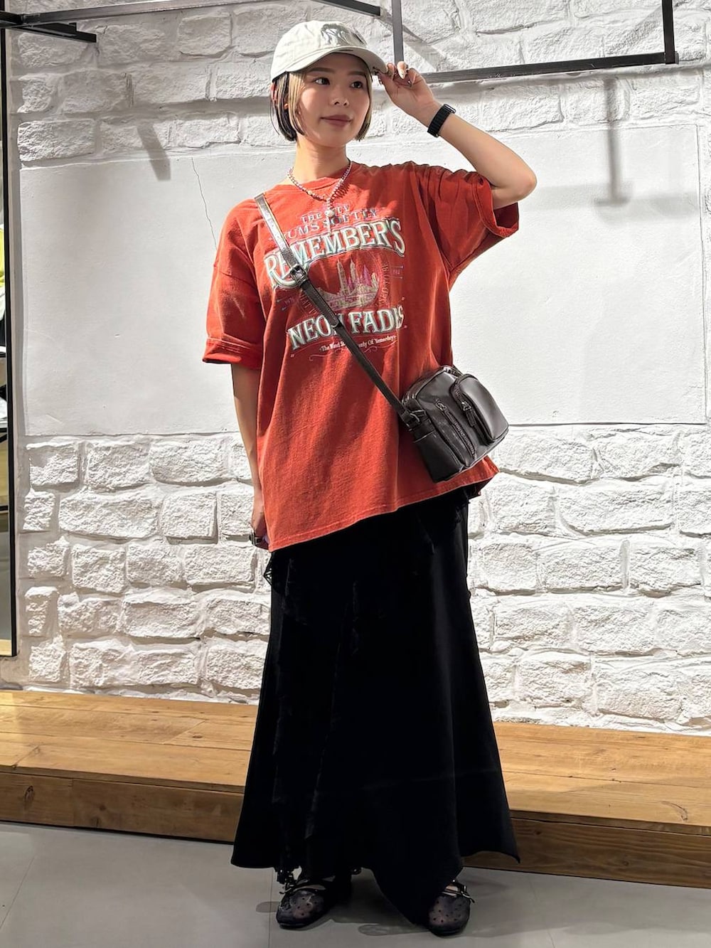 ブラウン系のショルダーバッグ、ブラック系のパンプス、レッド系のTシャツ/カットソーを着用したレディースの春コーディネートの2枚目の写真
