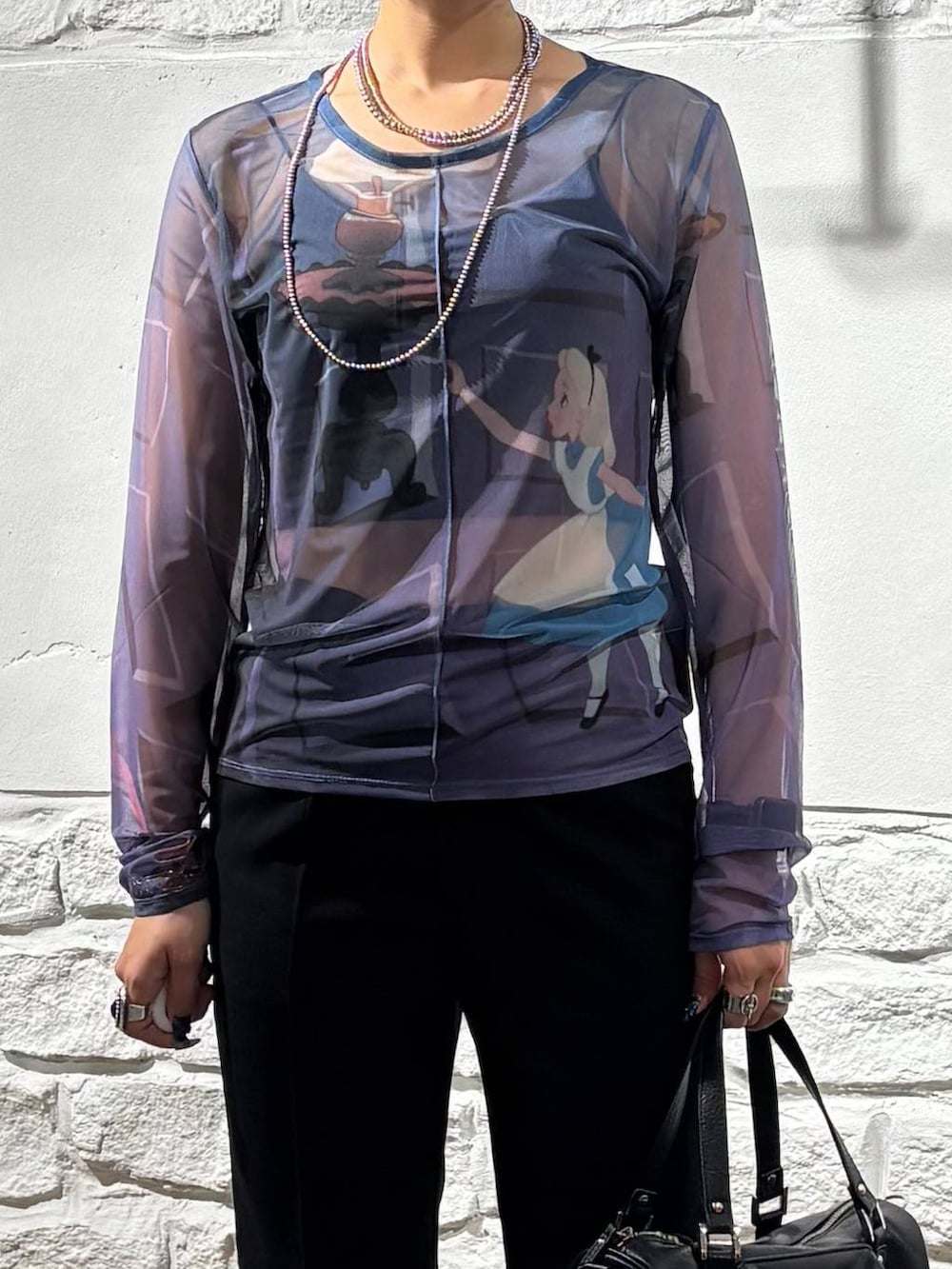 ブラック系のショルダーバッグ、ブラック系のスラックス、ブルー系のTシャツ/カットソーを着用したレディースの夏コーディネートの4枚目の写真