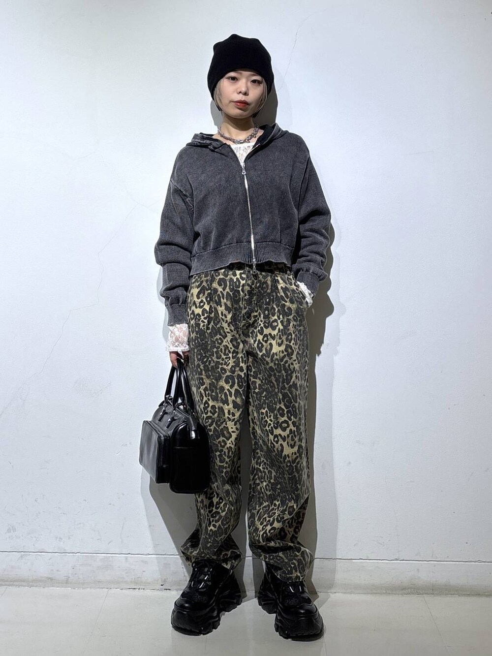 ブラック系のスニーカー、ホワイト系のTシャツ/カットソー、ブラウン系のデニムパンツを着用したレディースの冬コーディネートの3枚目の写真