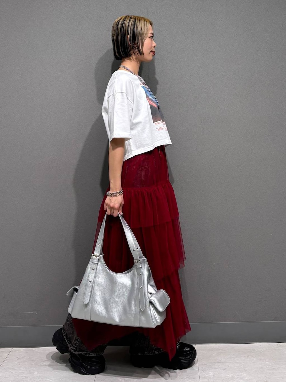 ブラック系のスニーカー、ブラック系のデニムパンツ、ホワイト系のTシャツ/カットソーを着用したレディースの春コーディネートの4枚目の写真