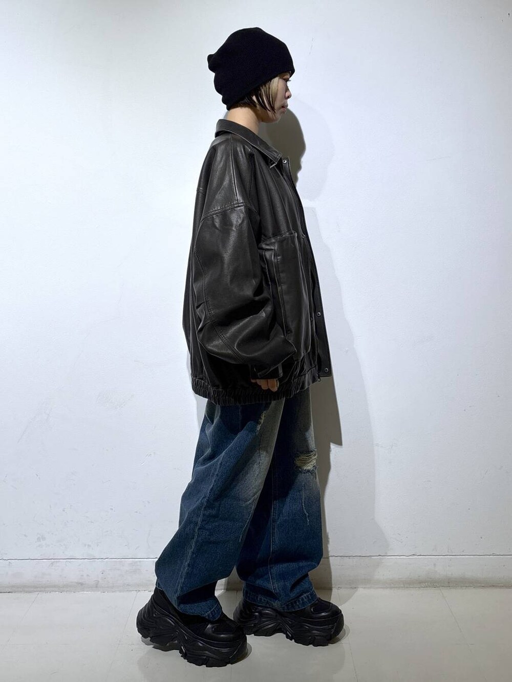 ブラック系のブーツ、ブラック系のブルゾン、グレー系のニット/セーターを着用したレディースの秋コーディネートの3枚目の写真