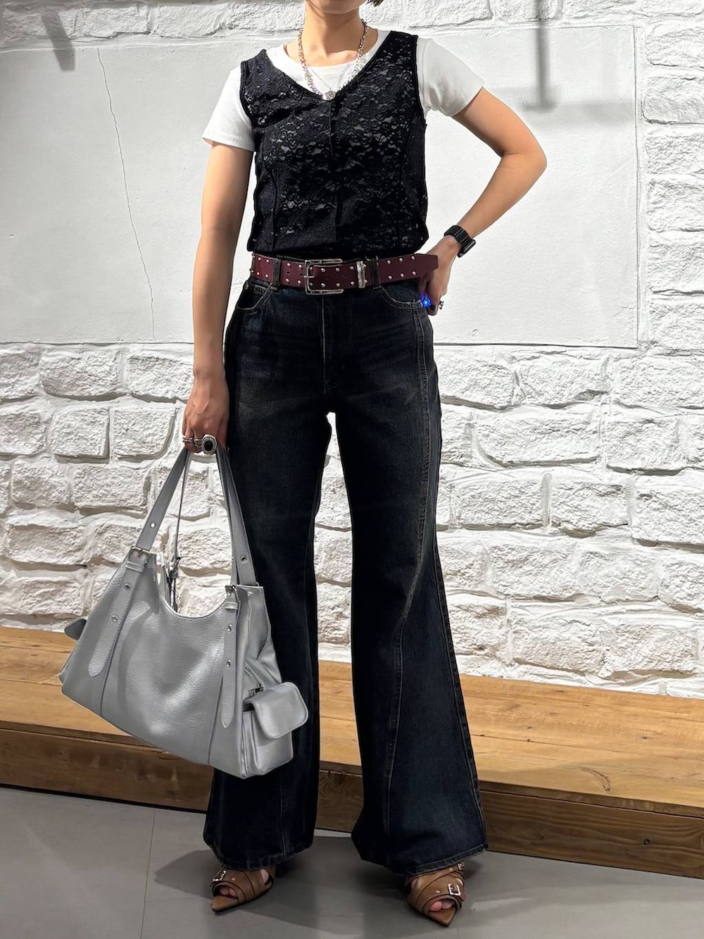 ブルー系のデニムパンツ、イエロー系のサンダル、シルバー系のハンドバッグを着用したレディースの春コーディネートの3枚目の写真