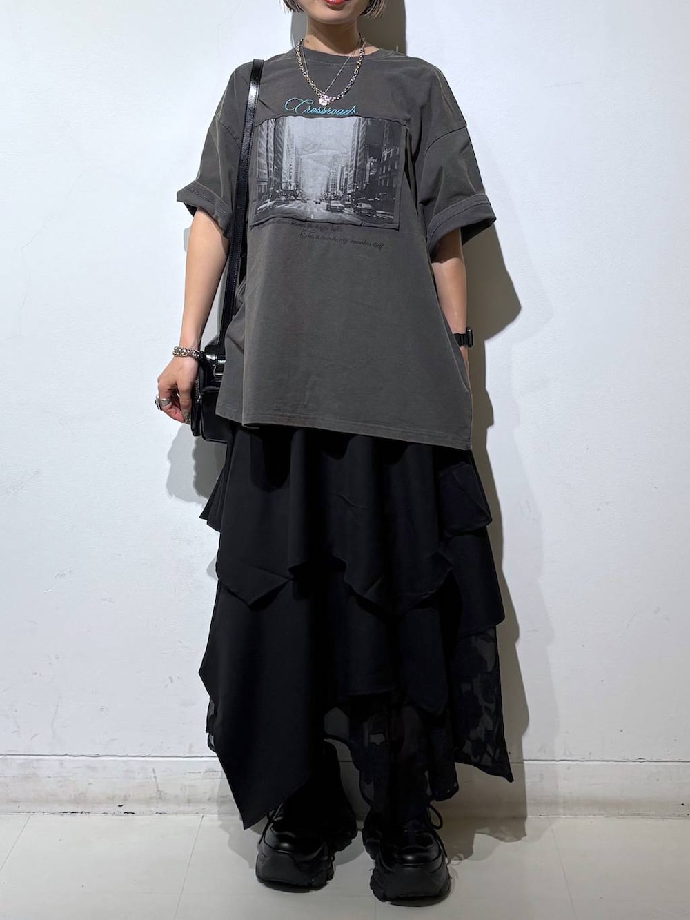 ブラック系のスニーカー、ブラック系のショルダーバッグ、グレー系のTシャツ/カットソーを着用したレディースの夏コーディネートの3枚目の写真