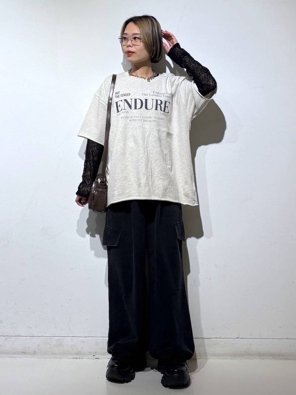 ブラック系のスニーカー、ブラウン系のショルダーバッグ、ブラック系のTシャツ/カットソーを着用したレディースの春コーディネートの7枚目の写真