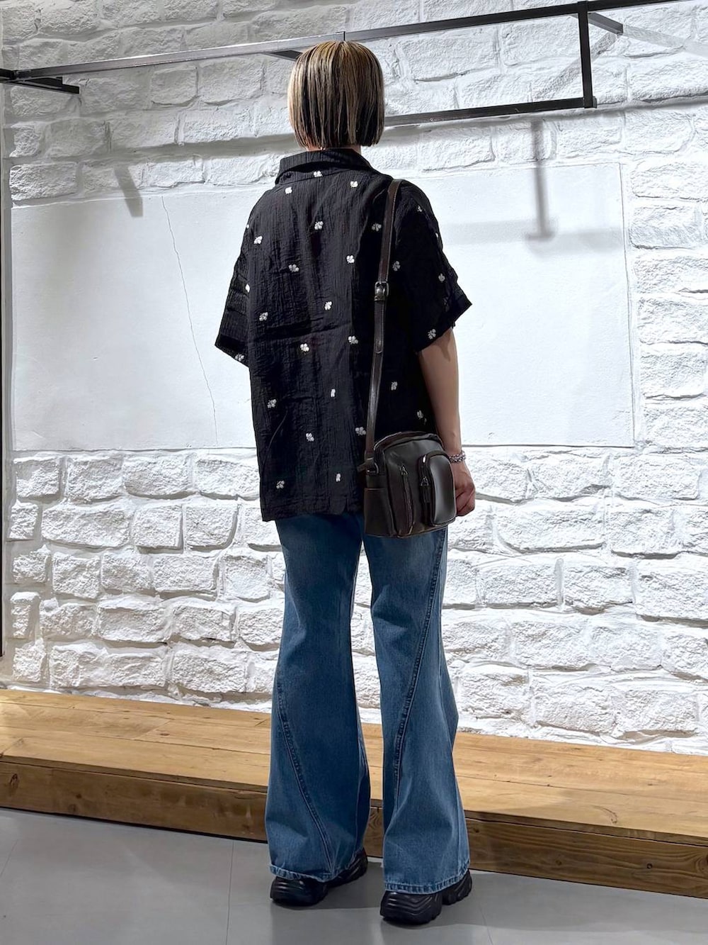 ブルー系のデニムパンツ、ブラウン系のショルダーバッグ、ブラック系のサンダルを着用したレディースの春コーディネートの5枚目の写真