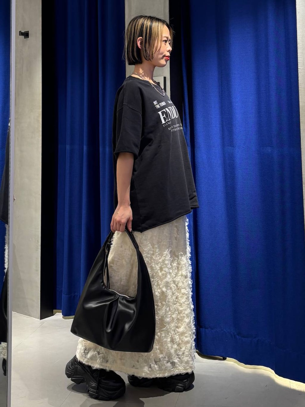 ブラック系のスニーカー、ブラック系のトートバッグ、ブラック系のTシャツ/カットソーを着用したレディースの春コーディネートの4枚目の写真