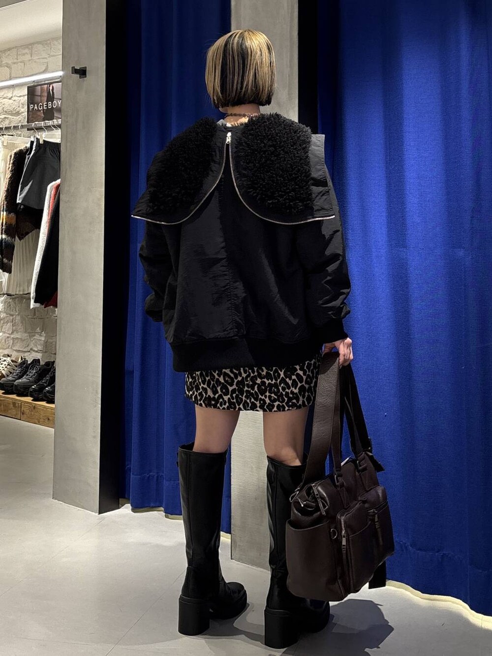 ブラック系のブーツ、ブラウン系のボストンバッグ、ブラック系のブルゾンを着用したレディースの冬コーディネートの4枚目の写真