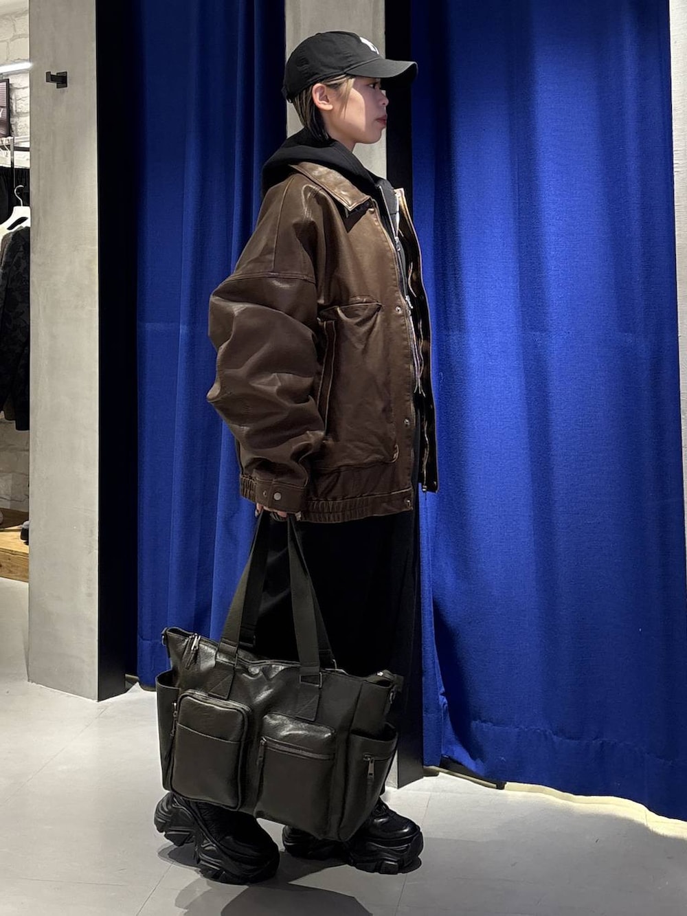 ブラック系のスニーカー、グリーン系のボストンバッグ、ブラック系のTシャツ/カットソーを着用したレディースの冬コーディネートの5枚目の写真