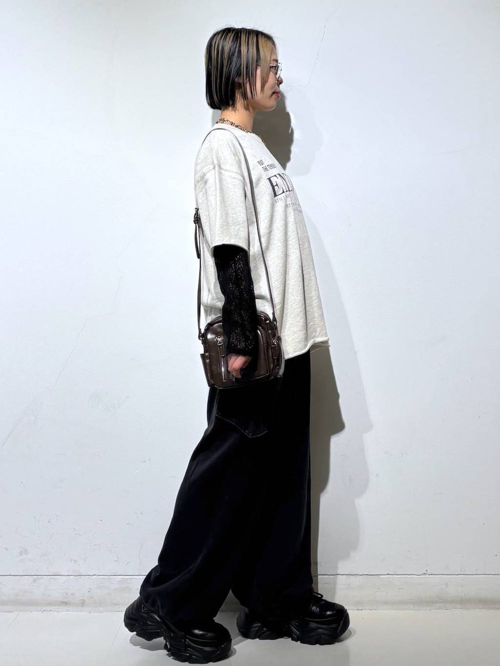 ブラック系のスニーカー、ブラウン系のショルダーバッグ、ブラック系のTシャツ/カットソーを着用したレディースの春コーディネートの8枚目の写真