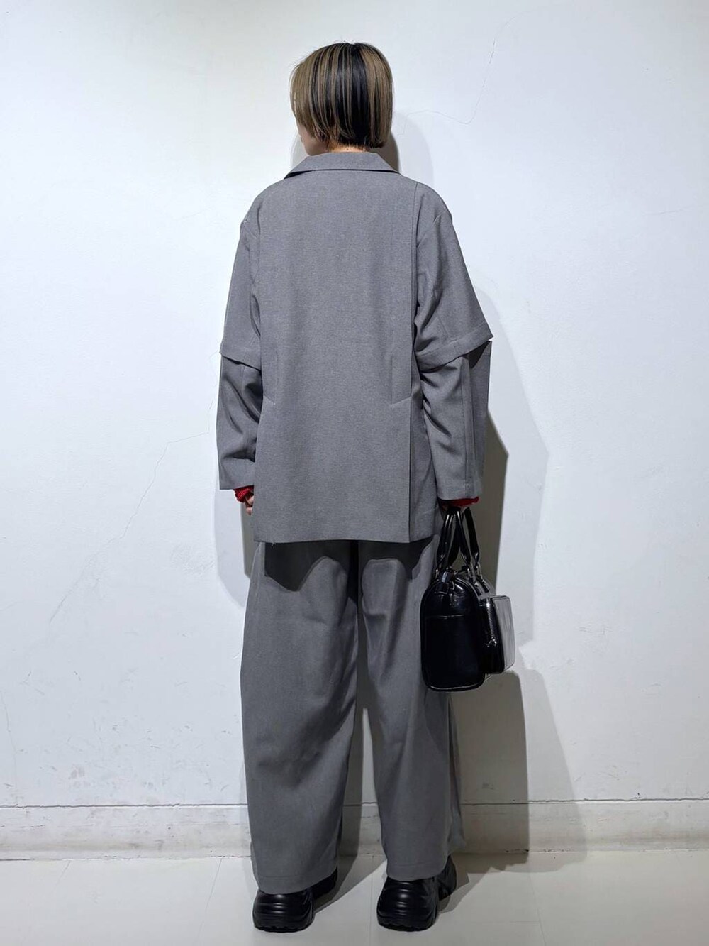 ブラック系のスニーカー、ブラック系のショルダーバッグ、ホワイト系のTシャツ/カットソーを着用したレディースの春コーディネートの4枚目の写真