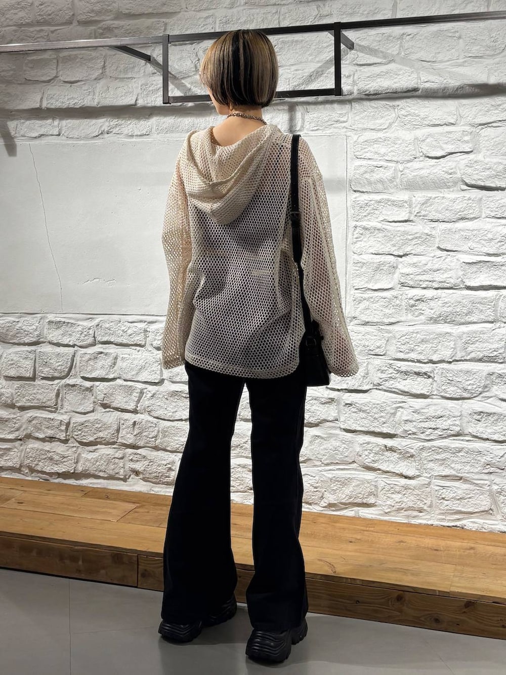 ホワイト系のパーカー、ブラック系のデニムパンツ、ブラック系のショルダーバッグを着用したレディースの夏コーディネートの5枚目の写真