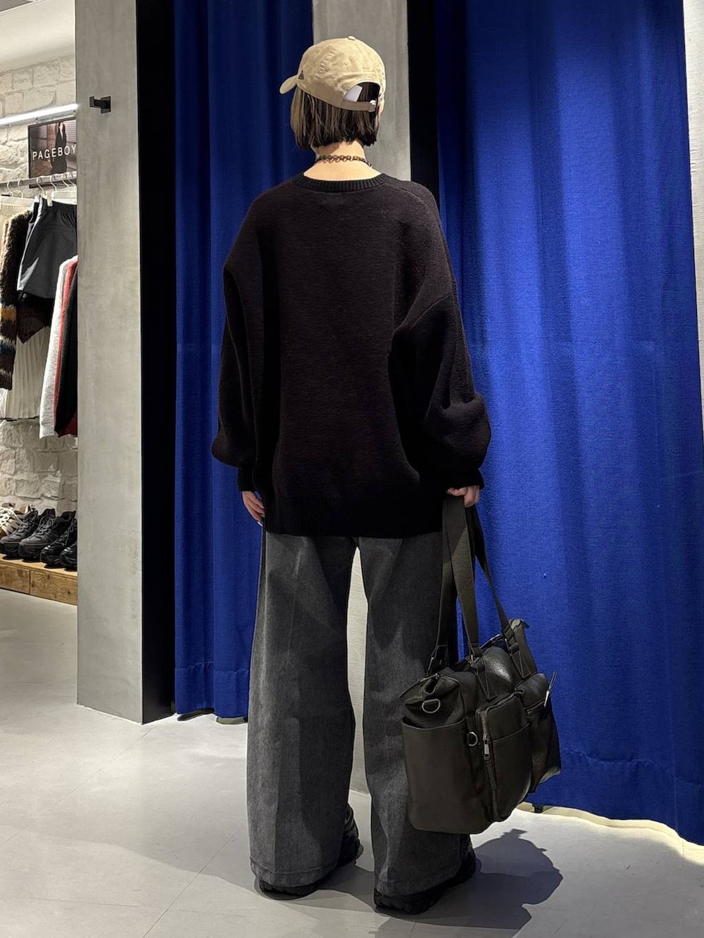 ブラック系のスニーカー、グリーン系のボストンバッグ、ブラック系のニット/セーターを着用したレディースの冬コーディネートの4枚目の写真