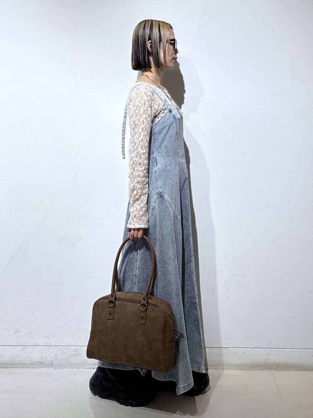 ブラック系のブーツ、ベージュ系のボストンバッグ、ブルー系のワンピースを着用したレディースの冬コーディネートの3枚目の写真