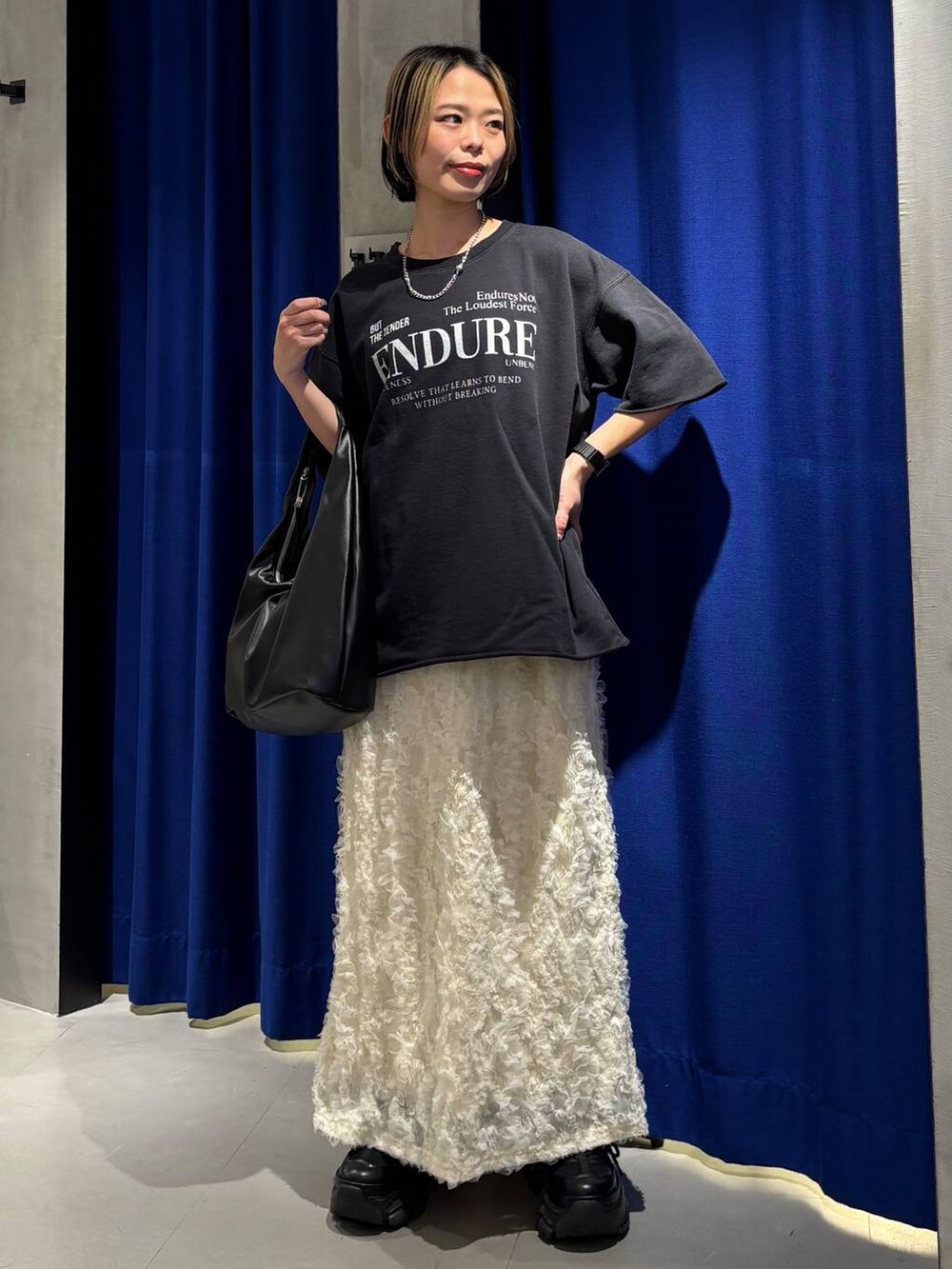 ブラック系のスニーカー、ブラック系のトートバッグ、ブラック系のTシャツ/カットソーを着用したレディースの春コーディネートの2枚目の写真