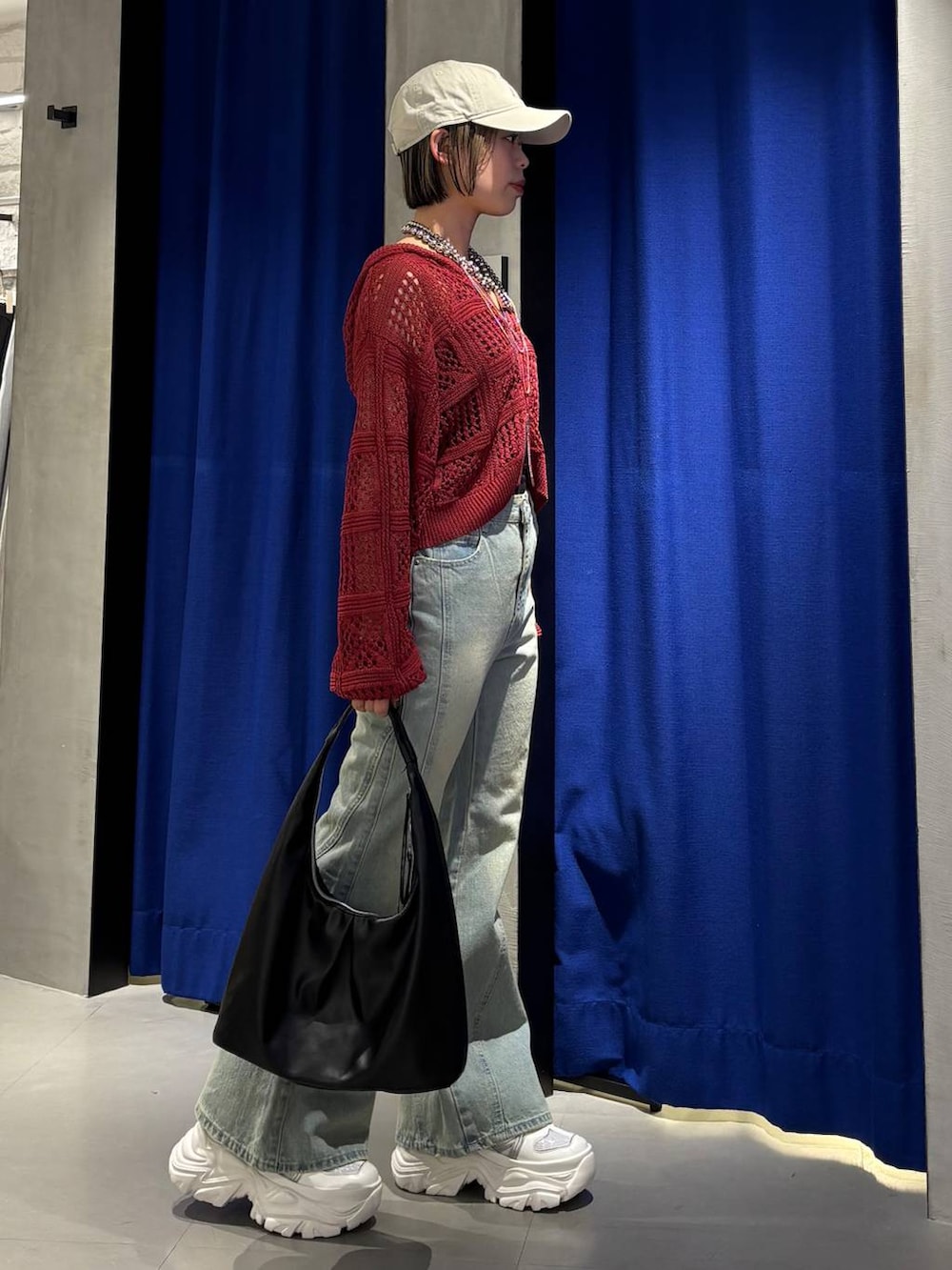 ホワイト系のスニーカー、ブラック系のキャミソール、ブルー系のデニムパンツを着用したレディースの春コーディネートの4枚目の写真