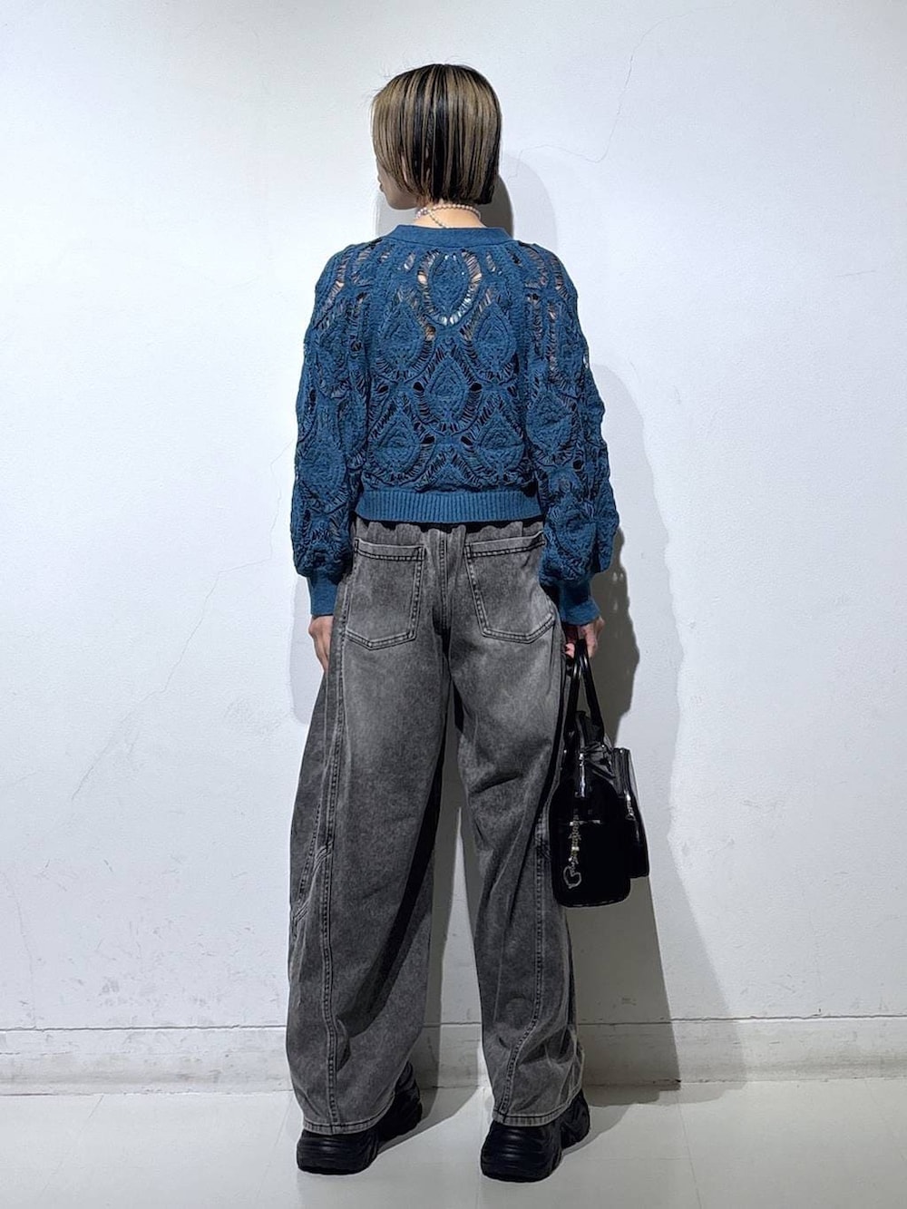 ブラック系のスニーカー、ブラック系のキャミソール、ブルー系のカーディガン/ボレロを着用したレディースの春コーディネートの5枚目の写真