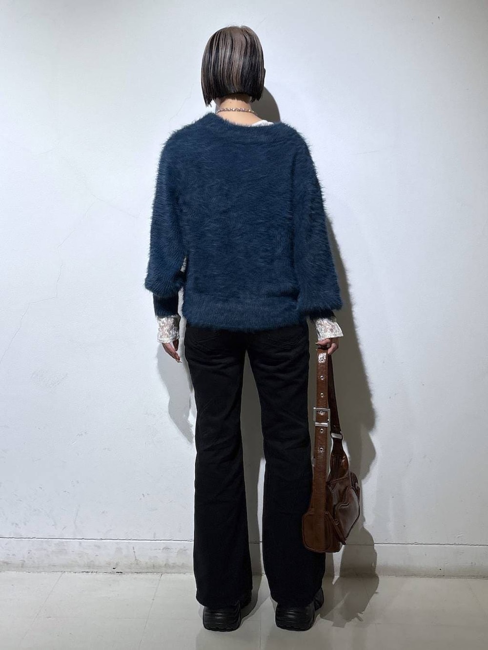 ブラック系のブーツ、ブラック系のデニムパンツ、ホワイト系のTシャツ/カットソーを着用したレディースの冬コーディネートの4枚目の写真