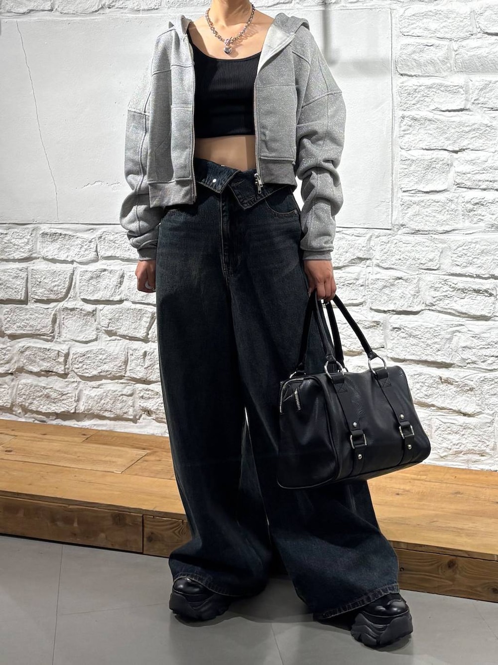 ブルー系のデニムパンツ、ブラック系のボストンバッグ、グレー系のパーカーを着用したレディースの秋コーディネートの3枚目の写真