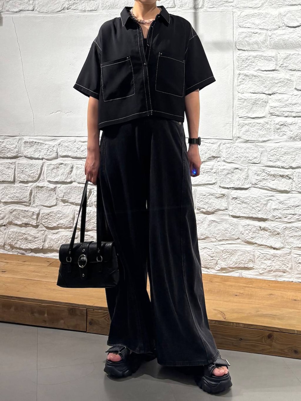 ブラック系のデニムパンツ、ブラック系のシャツ/ブラウス、ブラック系のキャミソールを着用したレディースの夏コーディネートの3枚目の写真