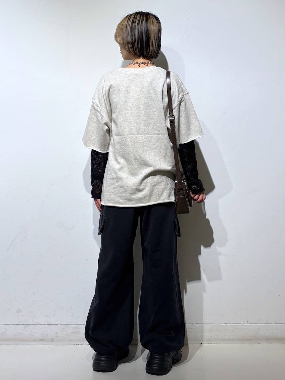 ブラック系のスニーカー、ブラウン系のショルダーバッグ、ブラック系のTシャツ/カットソーを着用したレディースの春コーディネートの9枚目の写真