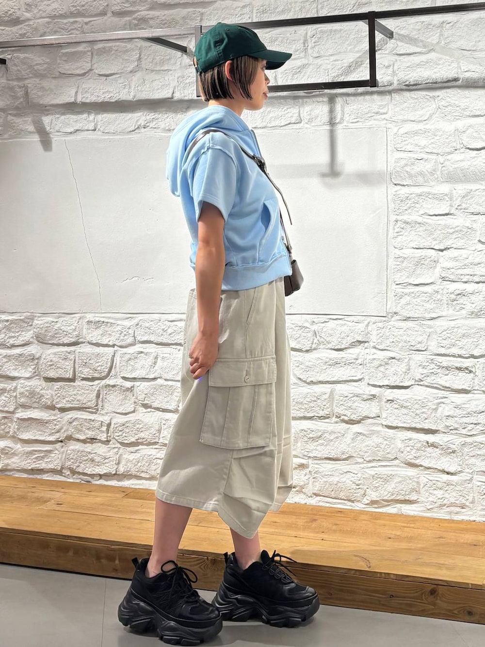 ブラック系のスニーカー、ブラウン系のショルダーバッグ、ブルー系のパーカーを着用したレディースの夏コーディネートの4枚目の写真