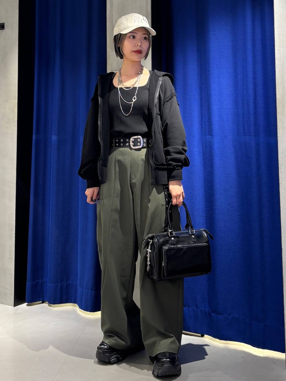 ブラック系のショルダーバッグ、ブラック系のタンクトップ、グリーン系のカーゴパンツを着用したレディースの春コーディネートの3枚目の写真