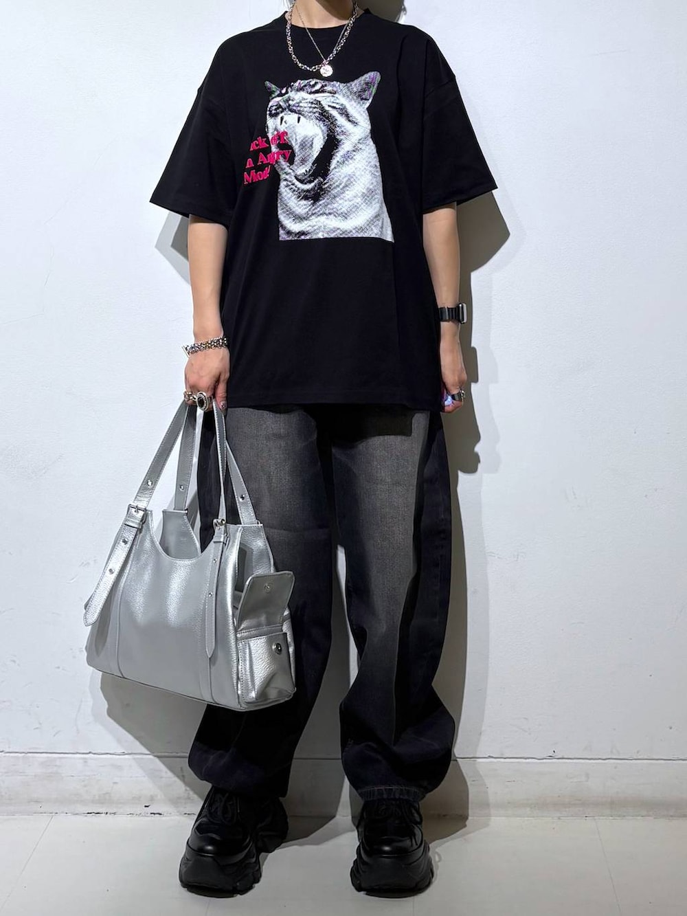 ブラック系のスニーカー、シルバー系のハンドバッグ、ブラック系のTシャツ/カットソーを着用したレディースの夏コーディネートの3枚目の写真