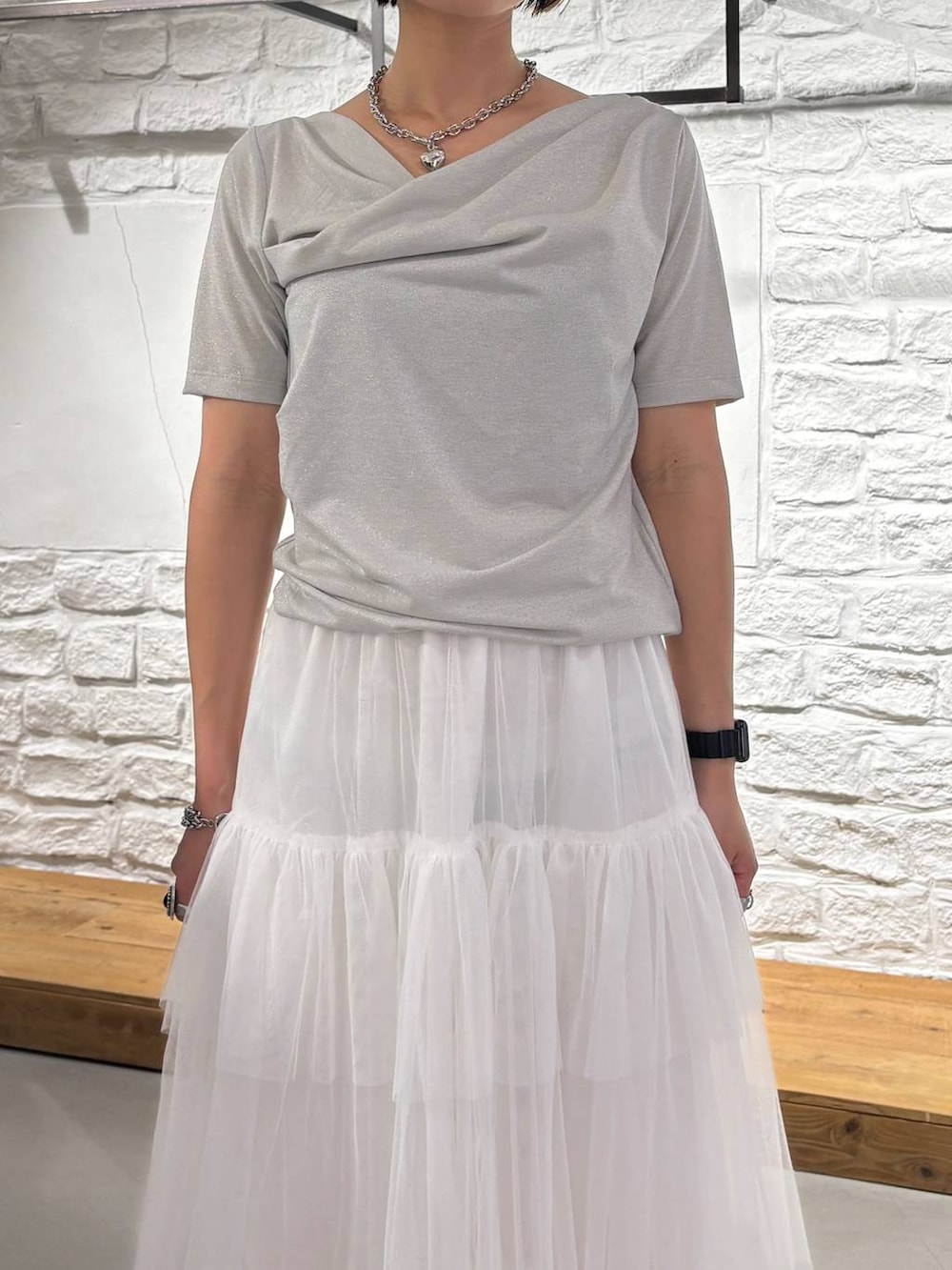 ブラック系のサンダル、ホワイト系のスカート、ベージュ系のTシャツ/カットソーを着用したレディースの夏コーディネートの4枚目の写真
