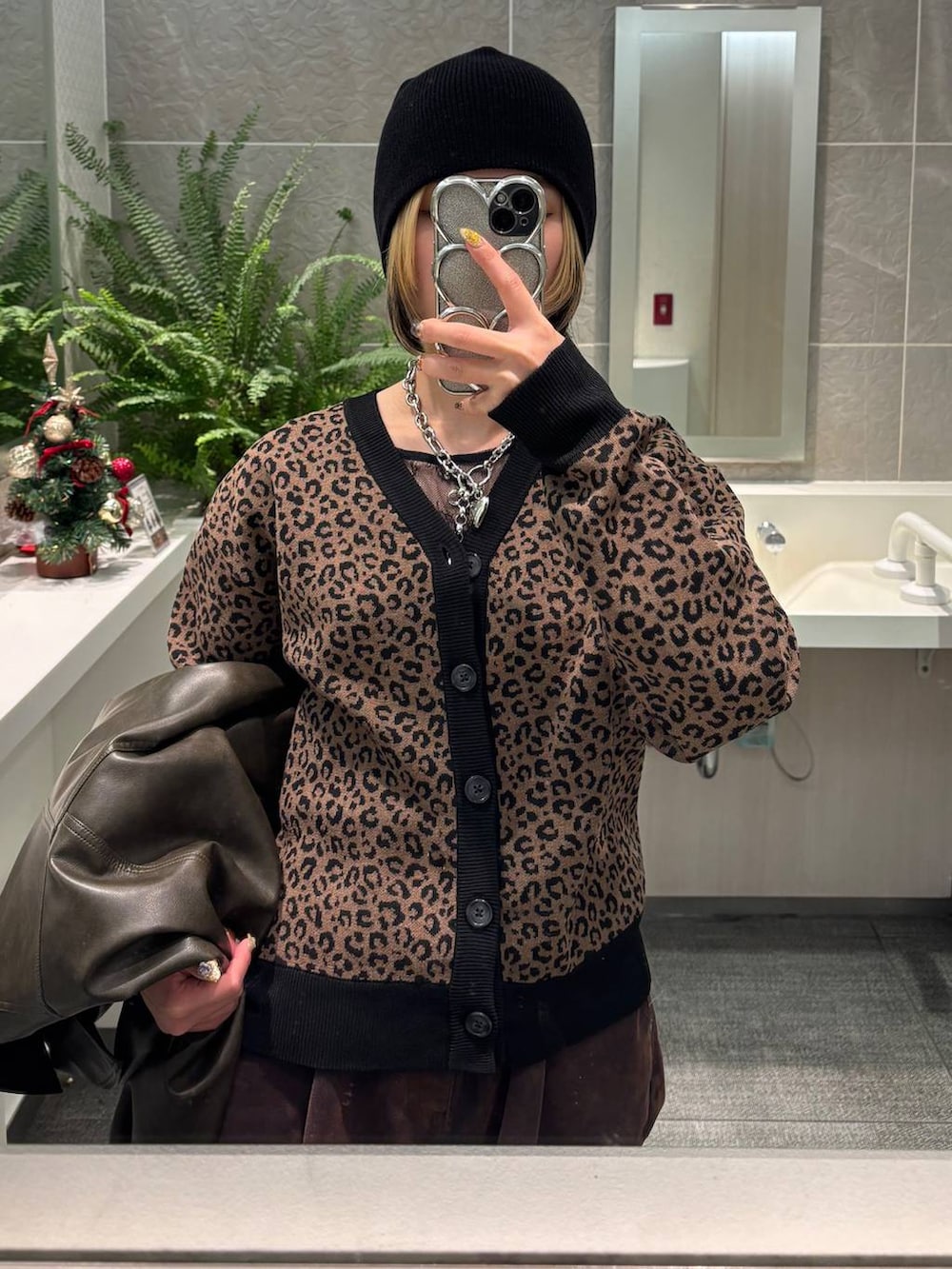 ブラウン系のカーディガン/ボレロ、ブルー系のデニムパンツ、ブラック系のニットキャップ/ビーニーを着用したレディースの冬コーディネートの2枚目の写真