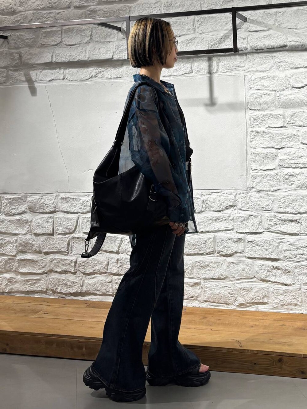 ブラック系のショルダーバッグ、ブルー系のシャツ/ブラウス、ブルー系のデニムパンツを着用したレディースの夏コーディネートの5枚目の写真