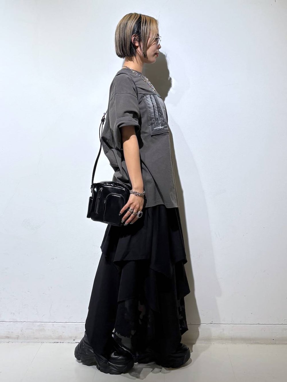 ブラック系のスニーカー、ブラック系のショルダーバッグ、グレー系のTシャツ/カットソーを着用したレディースの夏コーディネートの4枚目の写真