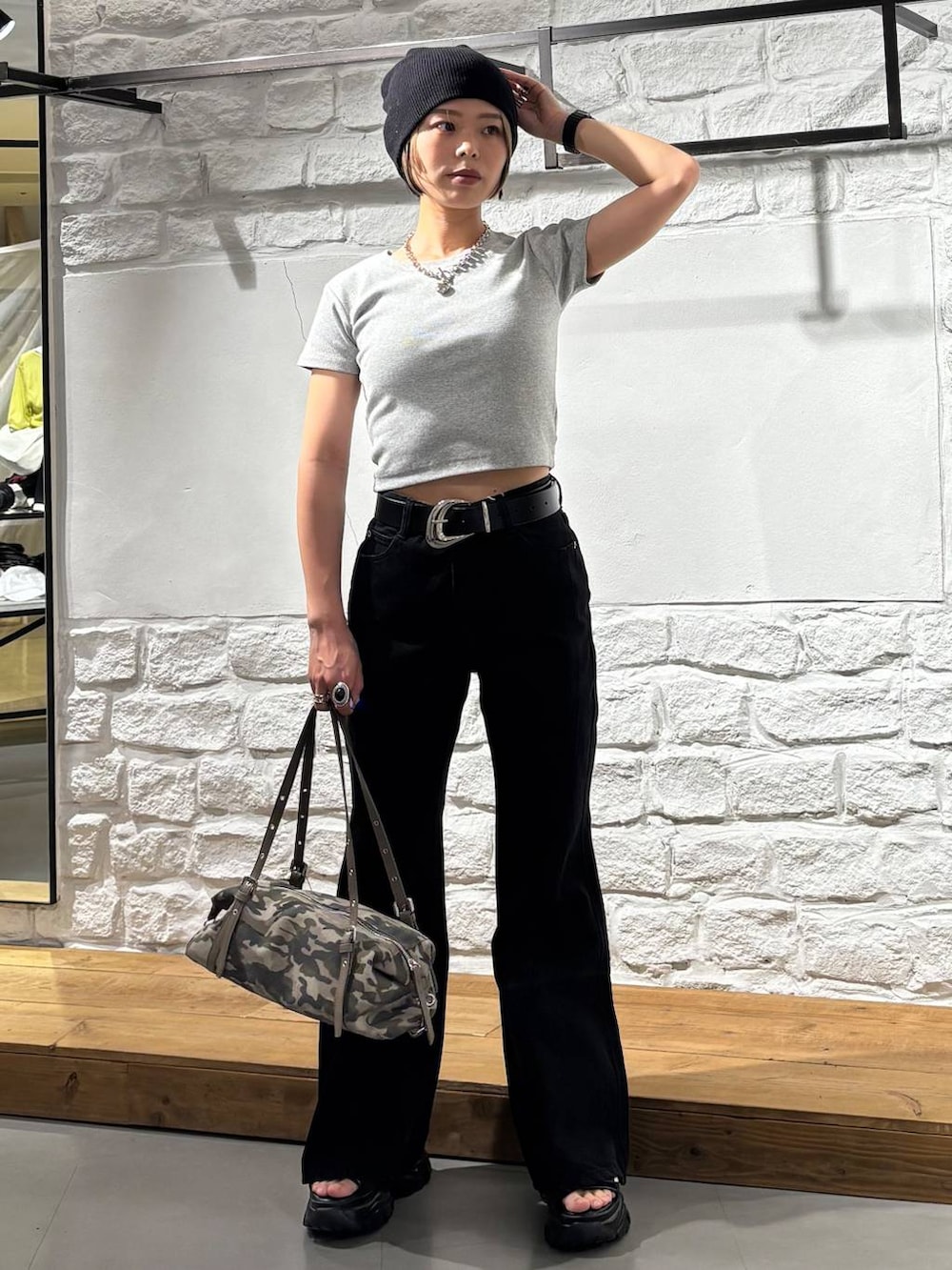 ブラック系のデニムパンツ、グレー系のTシャツ/カットソー、ブラック系のサンダルを着用したレディースの春コーディネートの2枚目の写真