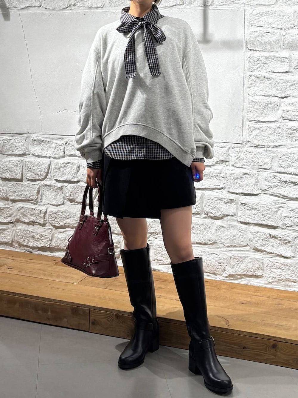 グレー系のスウェット、ブラック系のその他パンツ、ブラック系のブーツを着用したレディースの秋コーディネートの2枚目の写真