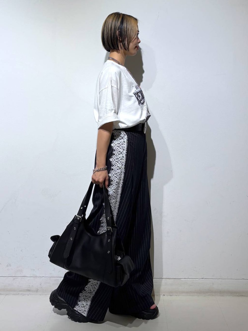 ブラック系のサンダル、ホワイト系のTシャツ/カットソー、ブルー系のスラックスを着用したレディースの夏コーディネートの4枚目の写真