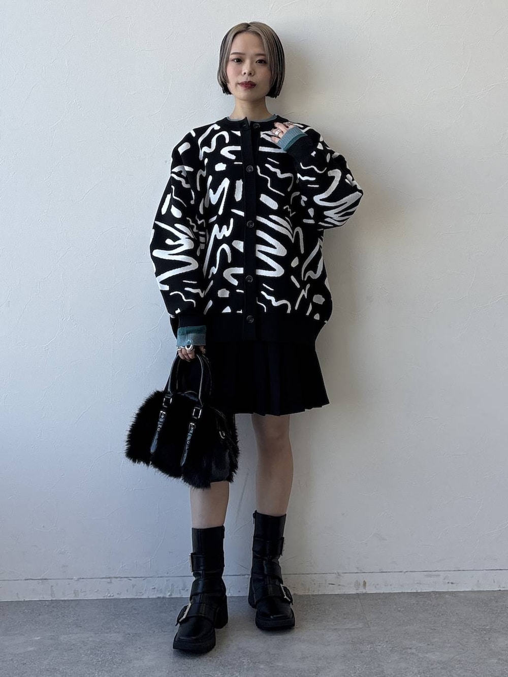 ブラック系のブーツ、ブラック系のボストンバッグ、ブラック系のその他パンツを着用したレディースの冬コーディネートの2枚目の写真