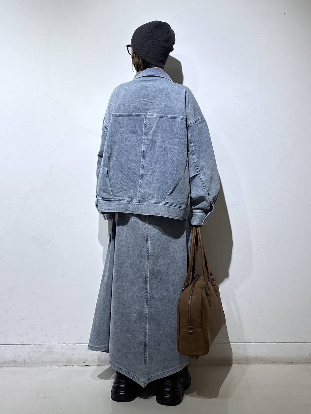 ブラック系のブーツ、ベージュ系のボストンバッグ、ホワイト系のTシャツ/カットソーを着用したレディースの春コーディネートの4枚目の写真