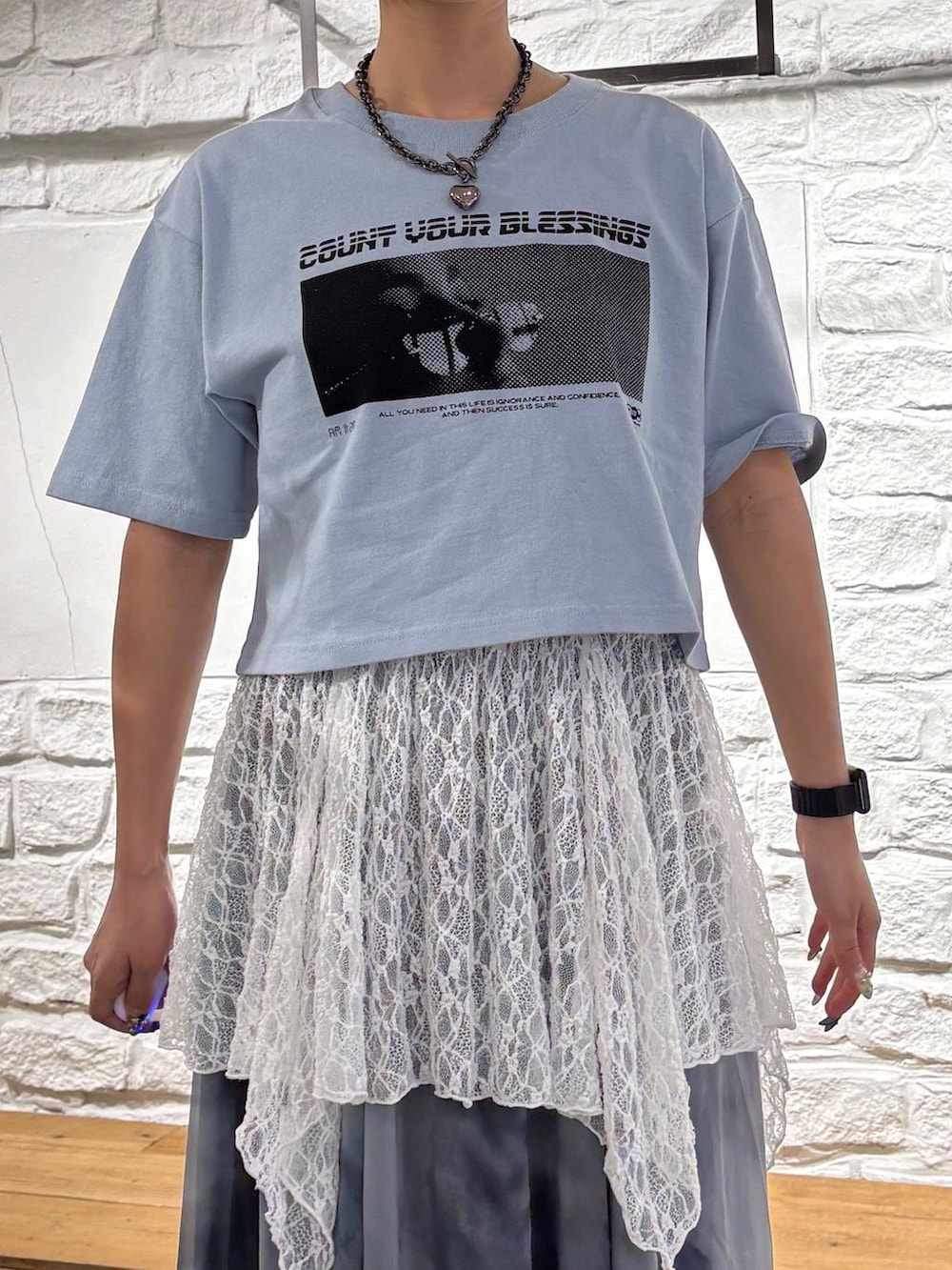 ブルー系のTシャツ/カットソー、グレー系のスカート、ブラック系のショルダーバッグを着用したレディースの夏コーディネートの4枚目の写真