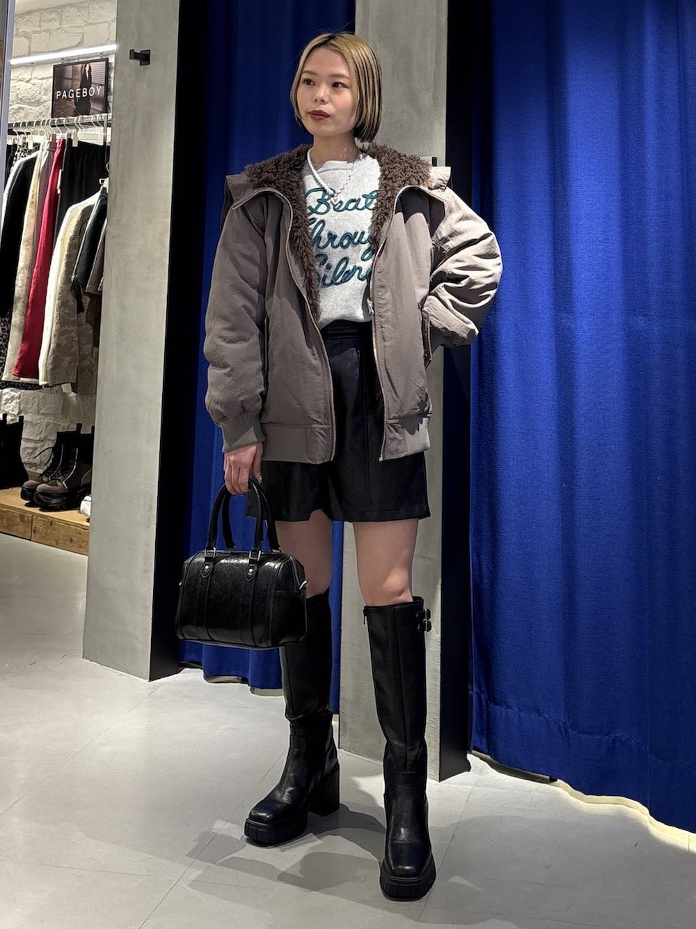 ブラック系のブーツ、ブラウン系のブルゾン、ブラック系のその他パンツを着用したレディースの冬コーディネートの3枚目の写真