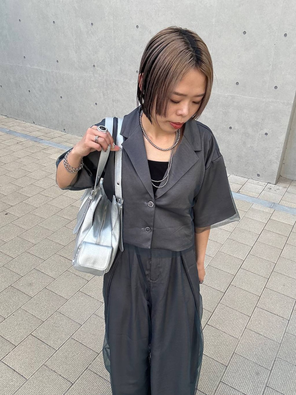 ブラック系のキャミソール、シルバー系のハンドバッグ、グレー系のその他パンツを着用したレディースの春コーディネートの5枚目の写真